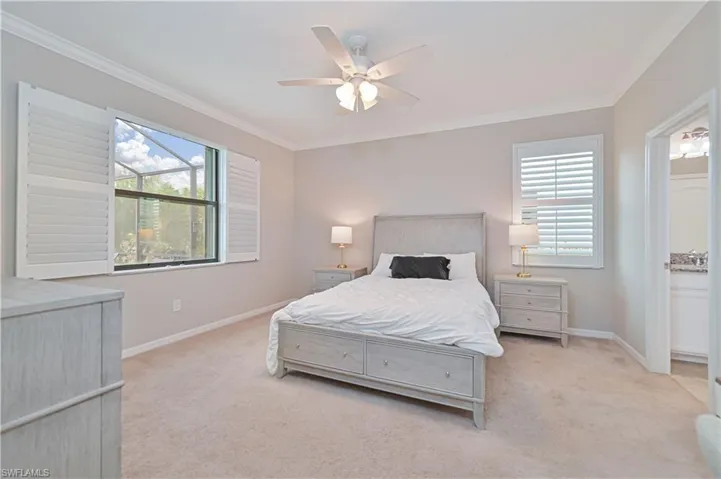 Bedroom with crown molding, multiple windows, and light colored carpet