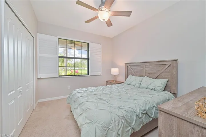 Carpeted bedroom featuring baseboards, a closet, and ceiling fan