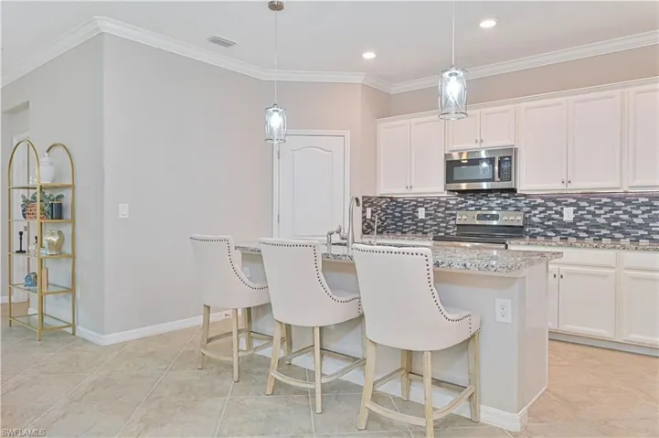 Kitchen featuring tasteful backsplash, visible vents, crown molding, stainless steel appliances, and a sink