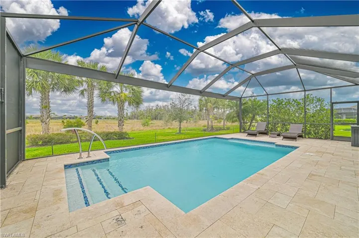 Outdoor pool featuring a yard, a patio, and a lanai