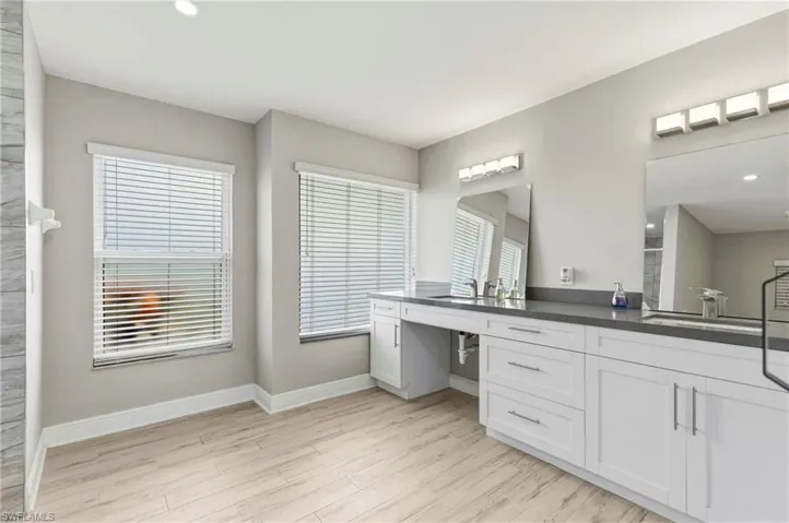 Full bath with vanity, light wood-style floors, recessed lighting, and a shower