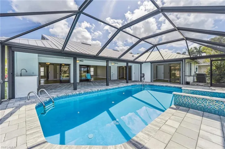 Swimming pool with a sunroom, a patio area, and a lanai