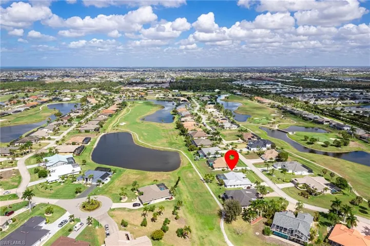 Aerial perspective of suburban area featuring a large body of water and a golf course