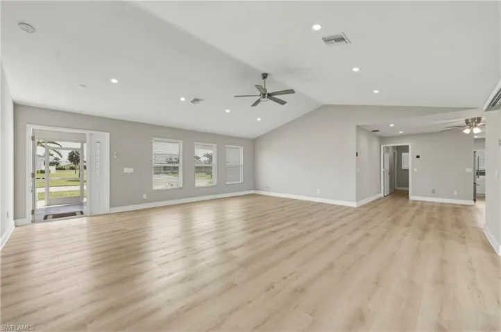 Unfurnished living room with ceiling fan, vaulted ceiling, light wood-style flooring, and recessed lighting