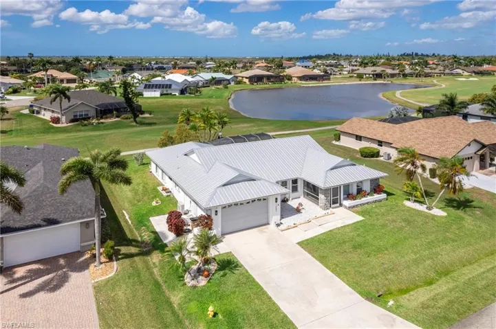 Aerial perspective of suburban area featuring a large body of water and a local golf course