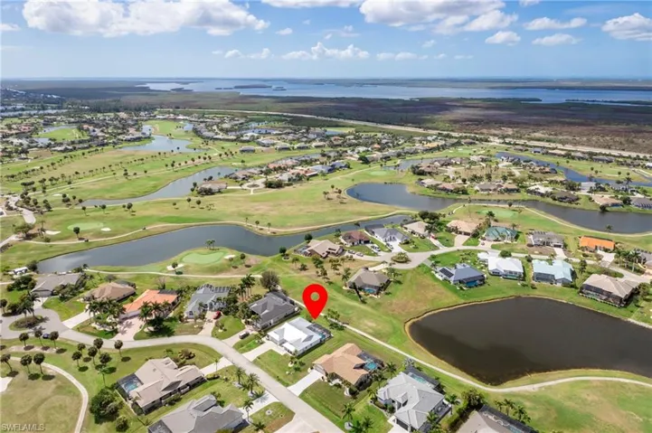 Aerial perspective of suburban area with a nearby body of water and a golf club