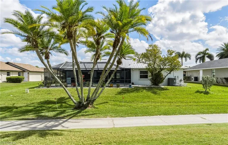 Ranch-style house with a lanai, a front yard, a sunroom, and stucco siding