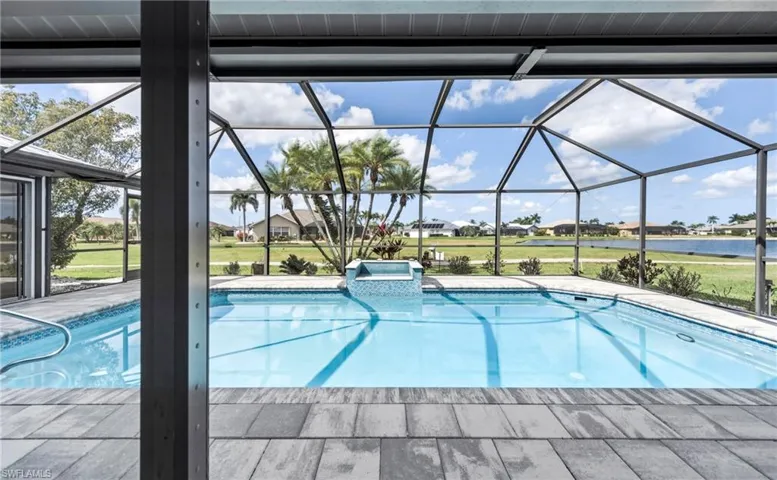 Integrated pool / spa featuring a sunroom, a patio area, a residential view, and a water view