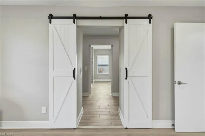 Hall featuring light wood-type flooring and a barn door