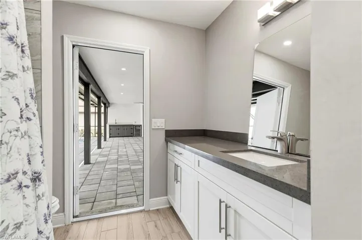 Full bathroom with vanity, recessed lighting, curtained shower, and light wood-type flooring
