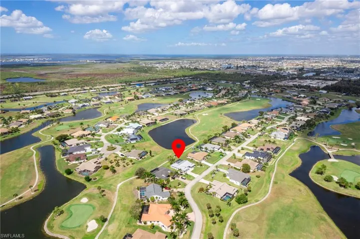 Aerial perspective of suburban area with a golf club and a large body of water