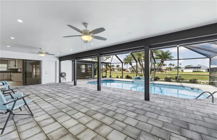 Combined pool / hot tub with a patio area, a sunroom, and a lanai