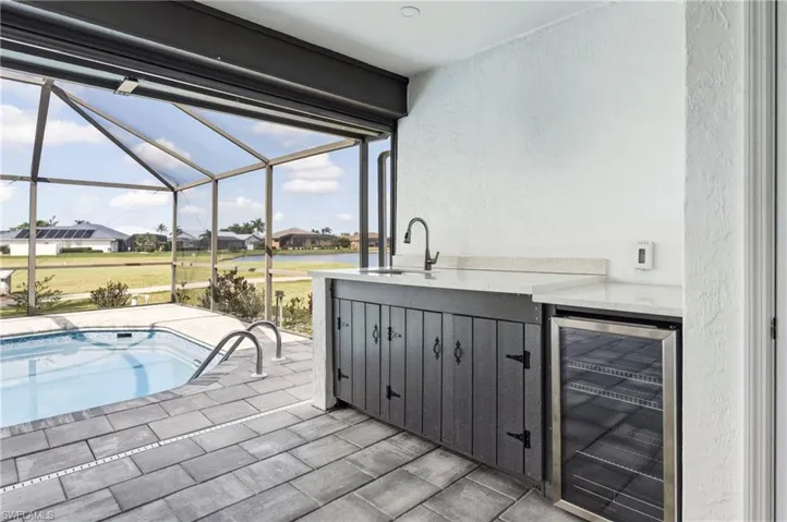 Swimming pool featuring a residential view, a sunroom, a patio, and a lanai