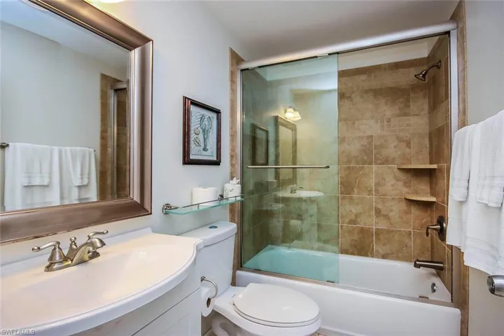 Bathroom featuring shower / bath combination with glass door and vanity