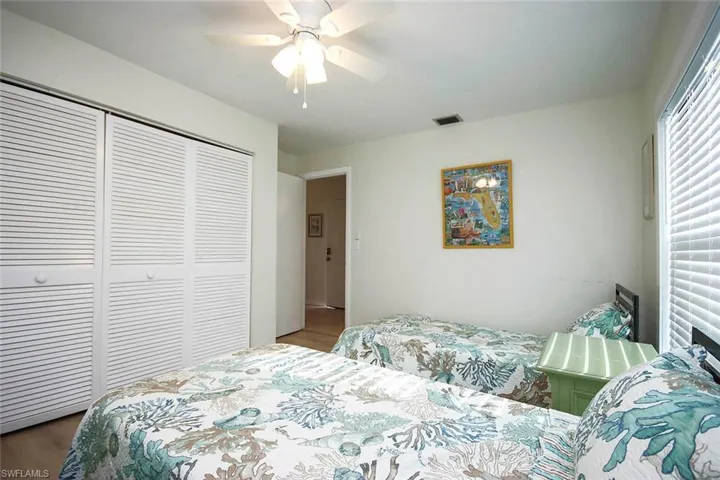 Bedroom with a closet, ceiling fan, and wood finished floors