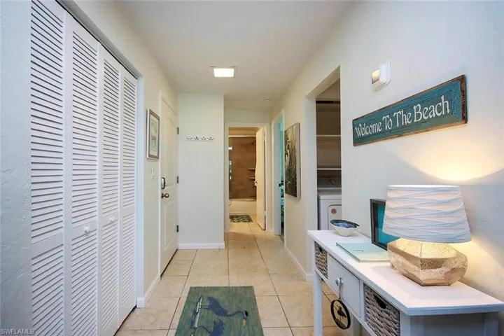 Hallway featuring light tile patterned flooring and washer / dryer