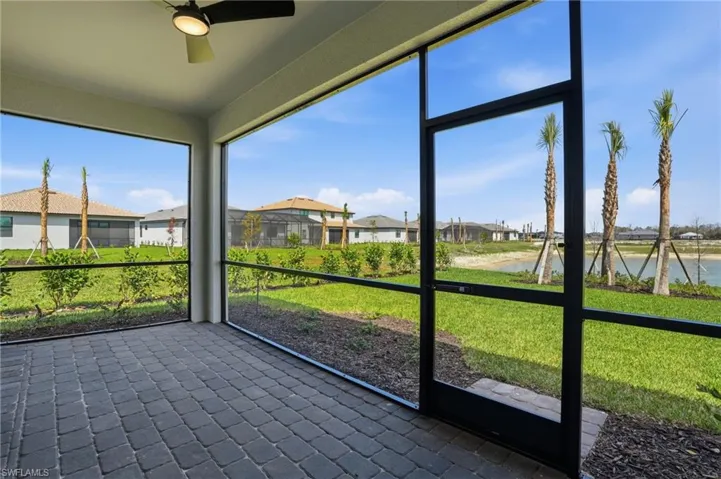 Unfurnished sunroom with ceiling fan, a residential view, and a water view