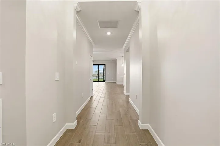 Hall featuring wood tiled floors and ornamental molding