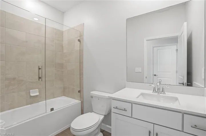 Bathroom featuring vanity and combined bath / shower with glass door