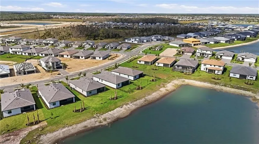 Aerial view of property and surrounding area with a nearby body of water and nearby suburban area