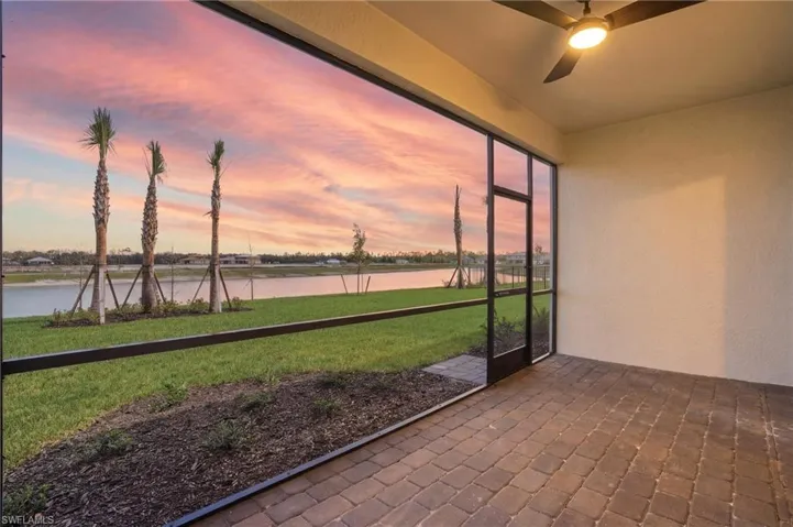 Unfurnished sunroom with ceiling fan and a water view