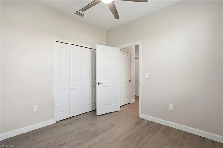 Unfurnished bedroom with light wood finished floors, a closet, and a ceiling fan