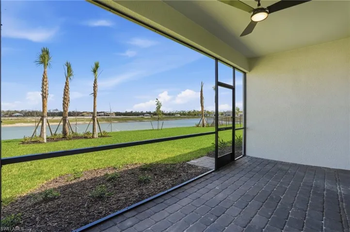 Unfurnished sunroom featuring ceiling fan and a water view