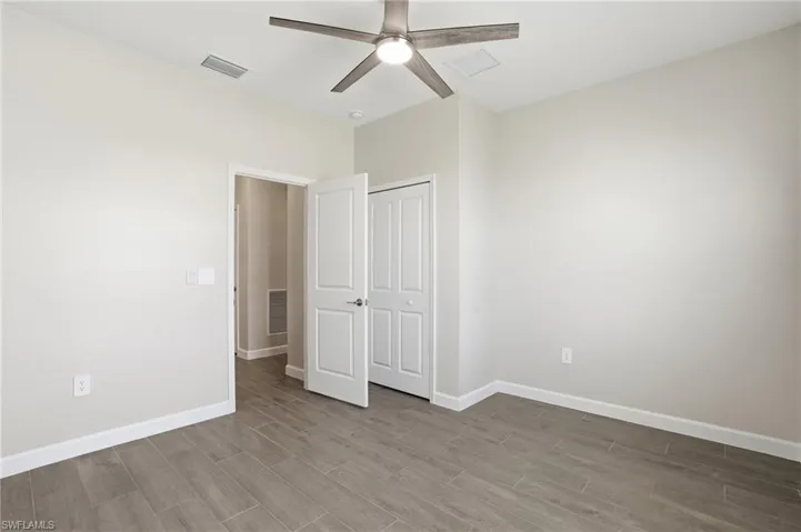 Unfurnished bedroom with light wood-style floors, a ceiling fan, and a closet