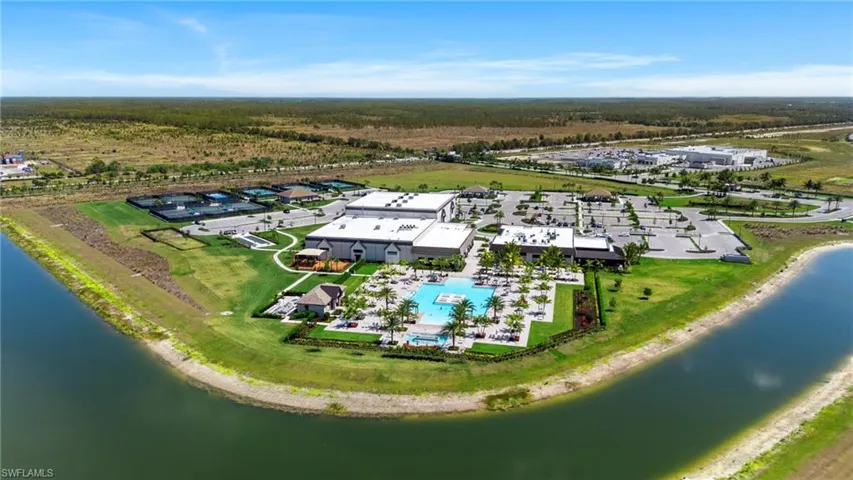 Drone / aerial view of a nearby body of water and a pool area