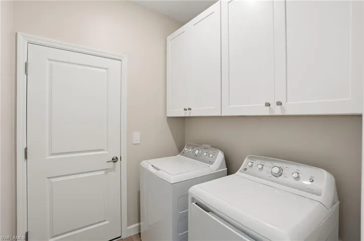 Laundry area featuring washing machine and dryer and cabinet space