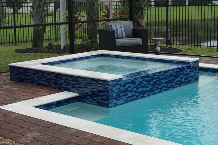 View of pool with a pool with connected hot tub and a patio area