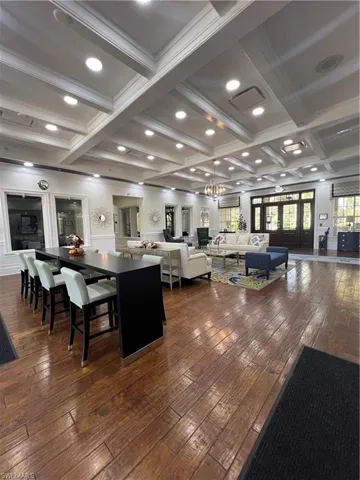 Building lobby featuring beamed ceiling, coffered ceiling, a wainscoted wall, and recessed lighting