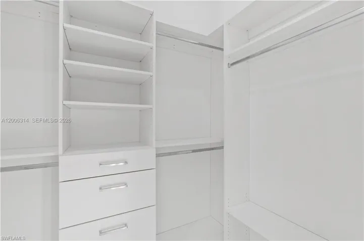 Custom closet system featuring white cabinetry