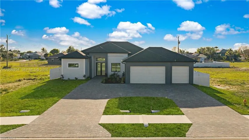 Modern single-story residence featuring a dark-tiled roof and a light gray and white exterior