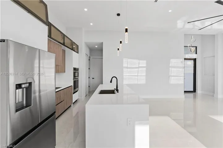 Modern kitchen featuring a large stainless steel refrigerator and built-in double ovens