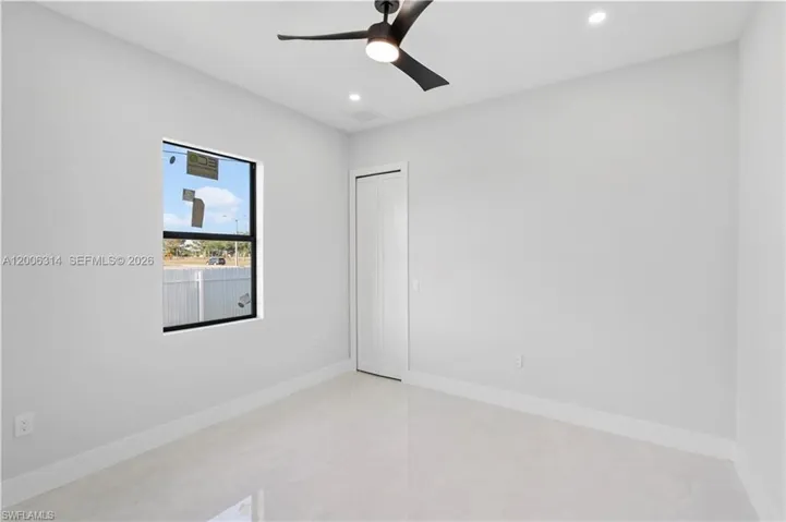 Bright room with a modern ceiling fan, recessed lighting, a single window, white baseboards, and light-colored tile flooring