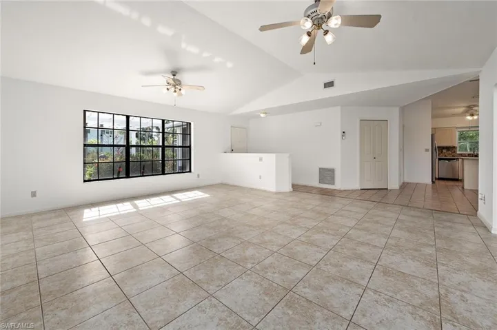 Living room opens to the kitchen w/vaulted ceiling.