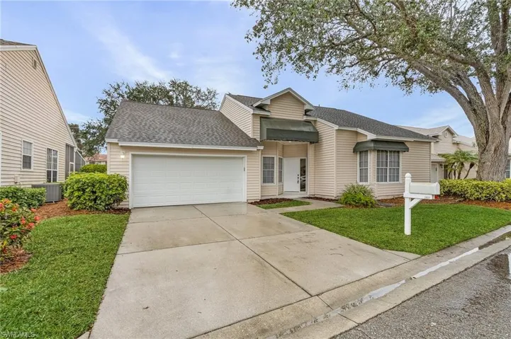 View of front of house with a garage, central AC, and a front yard
