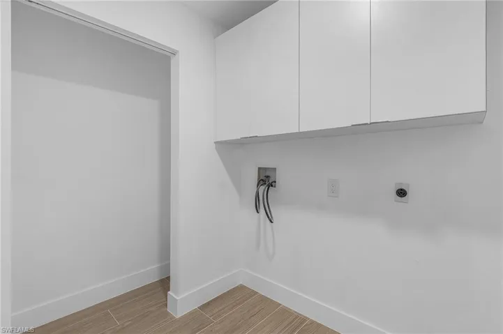 Laundry area with cabinets, washer hookup, and hookup for an electric dryer