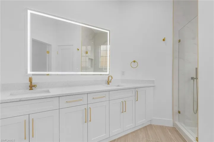 Bathroom featuring a tile shower and vanity