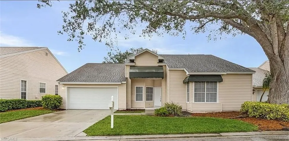 View of front of house with a garage and a front lawn