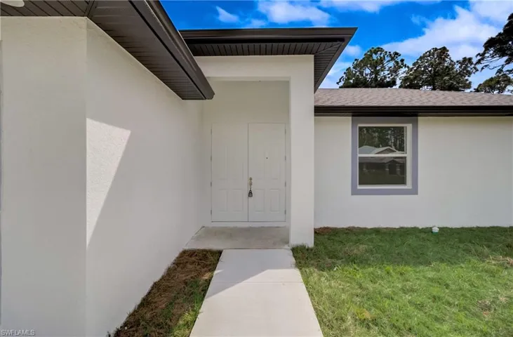 View of exterior entry featuring a yard