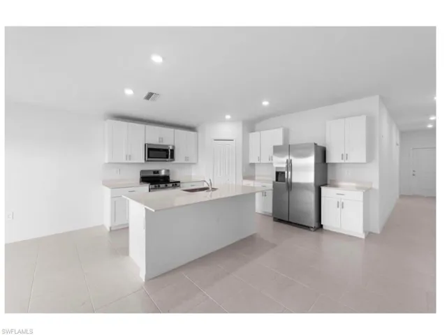 Modern kitchen with stainless steel appliances and center island.