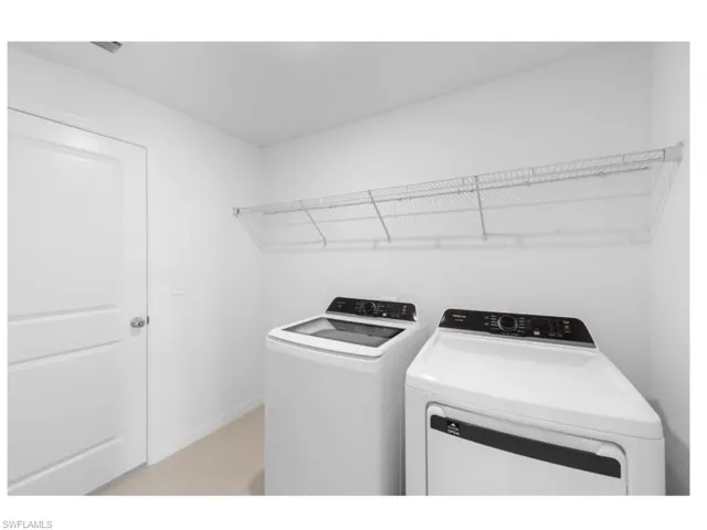 Convenient interior laundry room with full-size washer and dryer.
