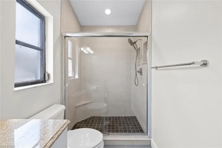 Full bath with vanity, tile patterned flooring, a shower stall, and toilet