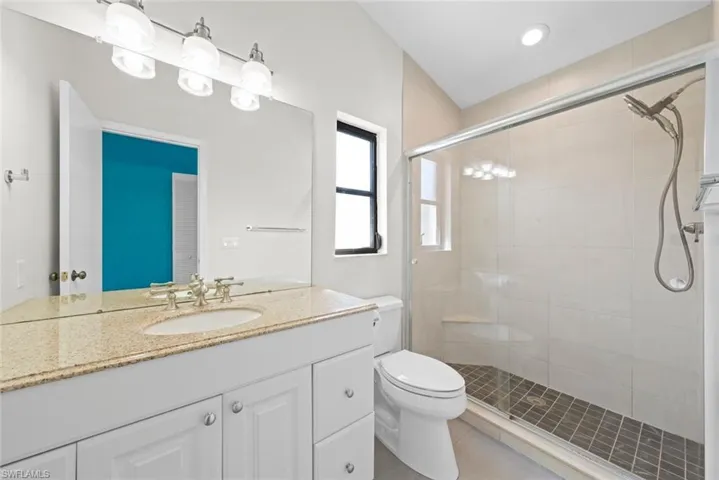 Full bath with vanity, tile patterned flooring, a shower stall, and toilet