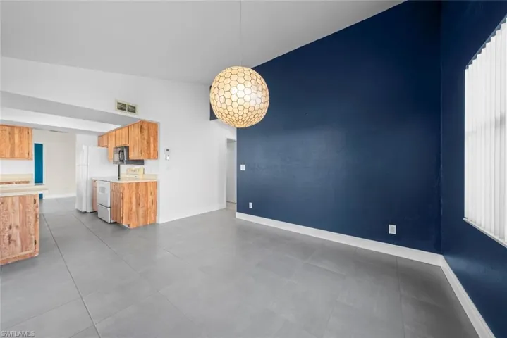 Unfurnished living room featuring lofted ceiling