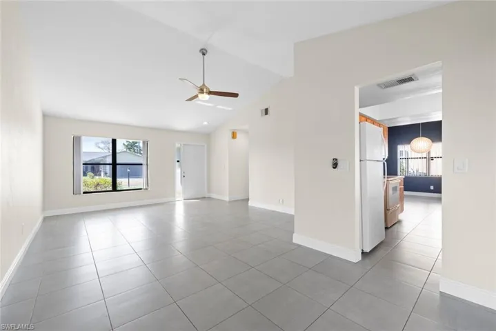Unfurnished room featuring vaulted ceiling, ceiling fan, and tile patterned flooring