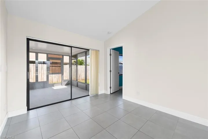 Spare room with lofted ceiling and light tile patterned floors