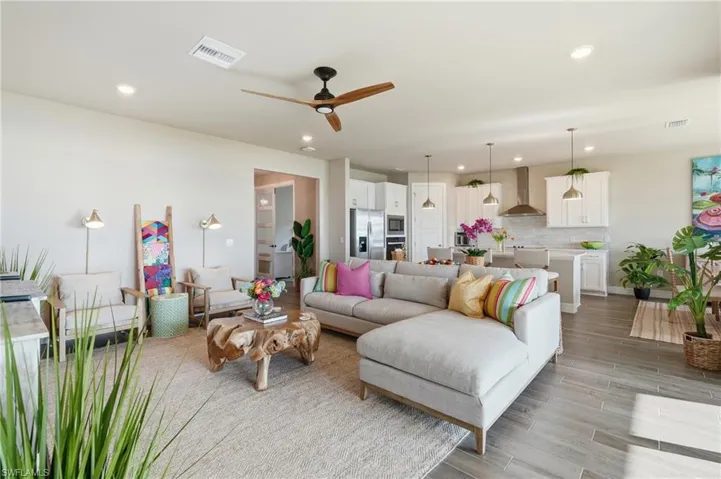 Recessed lighting, ceiling fan, wood-finish flooring, white cabinetry, and stainless steel appliances